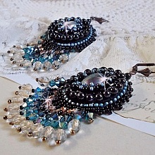 BO Angelot brod&eacute;es avec des cabochons ovales en r&eacute;sine Noire, perles rondes nacr&eacute;es Cristal et toupies. S&rsquo;ajoute des facettes et rocailles. Le tout est mont&eacute; sur des dormeuses Lys en Laiton